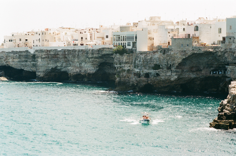 Italian seaside view of the cliff city of bari, white buildings and clear blue water