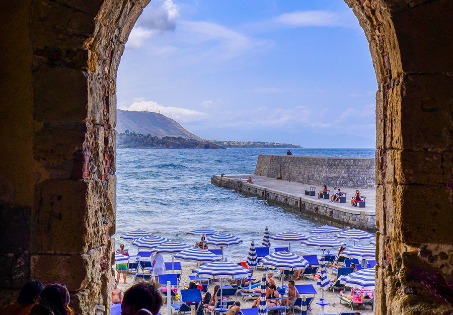 blue sun umbrellas off the coast of sicily