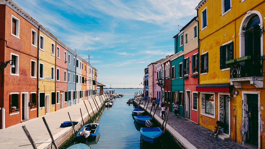 Venetian Italian Islands, Burano & Murano, colorful and rainbow like buildings with boats situated in the river bank