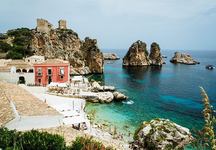 red villa off the coast of sicily with clear blue water on the coast