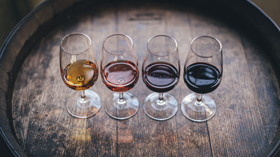 Four glasses of port wine situated on barrel at a tasting session in Porto, Portugal