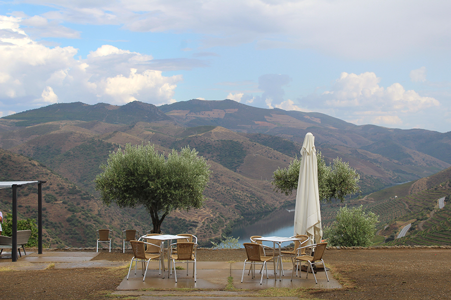 Hilltop view of Vega de Terrón vineyards with two lounge tables and chairs to take in the dramatic landscape in the fall